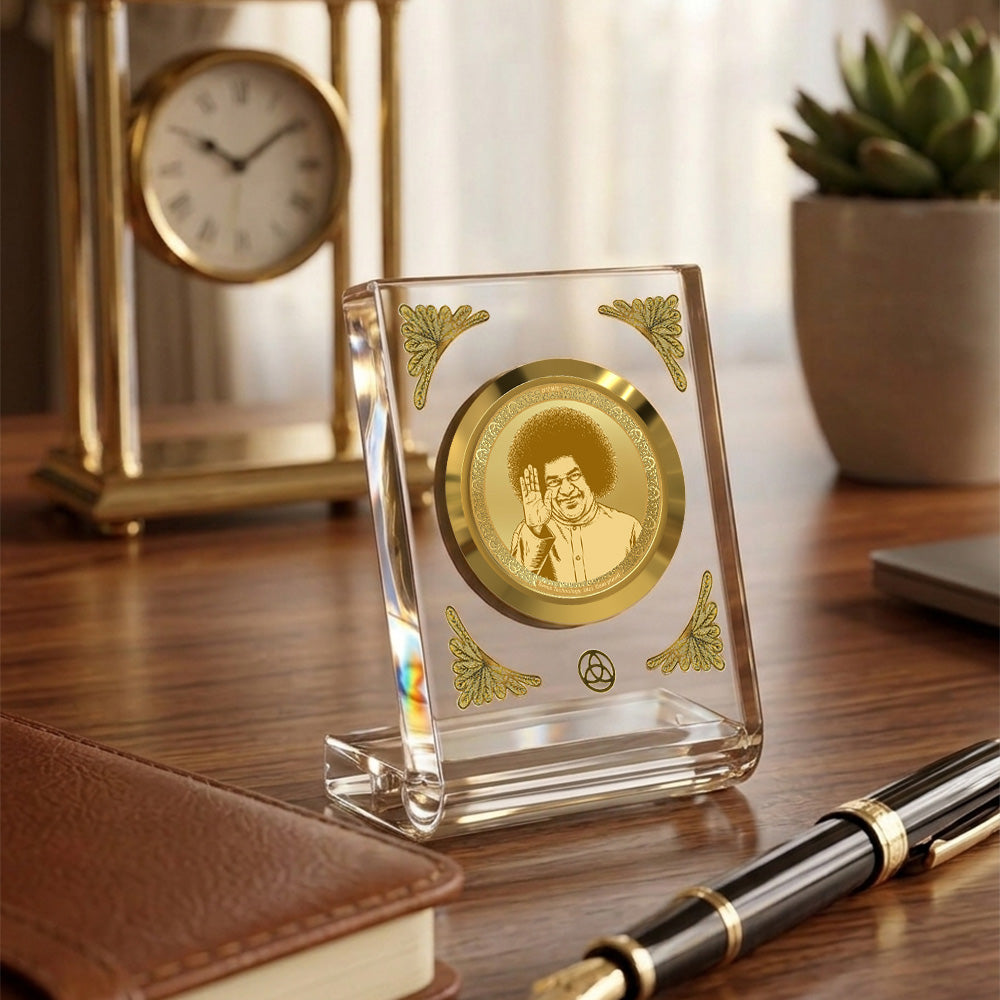 Satya Sai Baba 24K gold plated car dashboard frame elegantly displayed on a wooden desk.