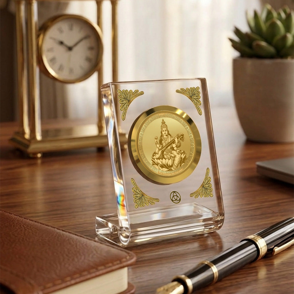 Saraswati Mata 24K gold plated car dashboard frame elegantly displayed on a wooden desk.