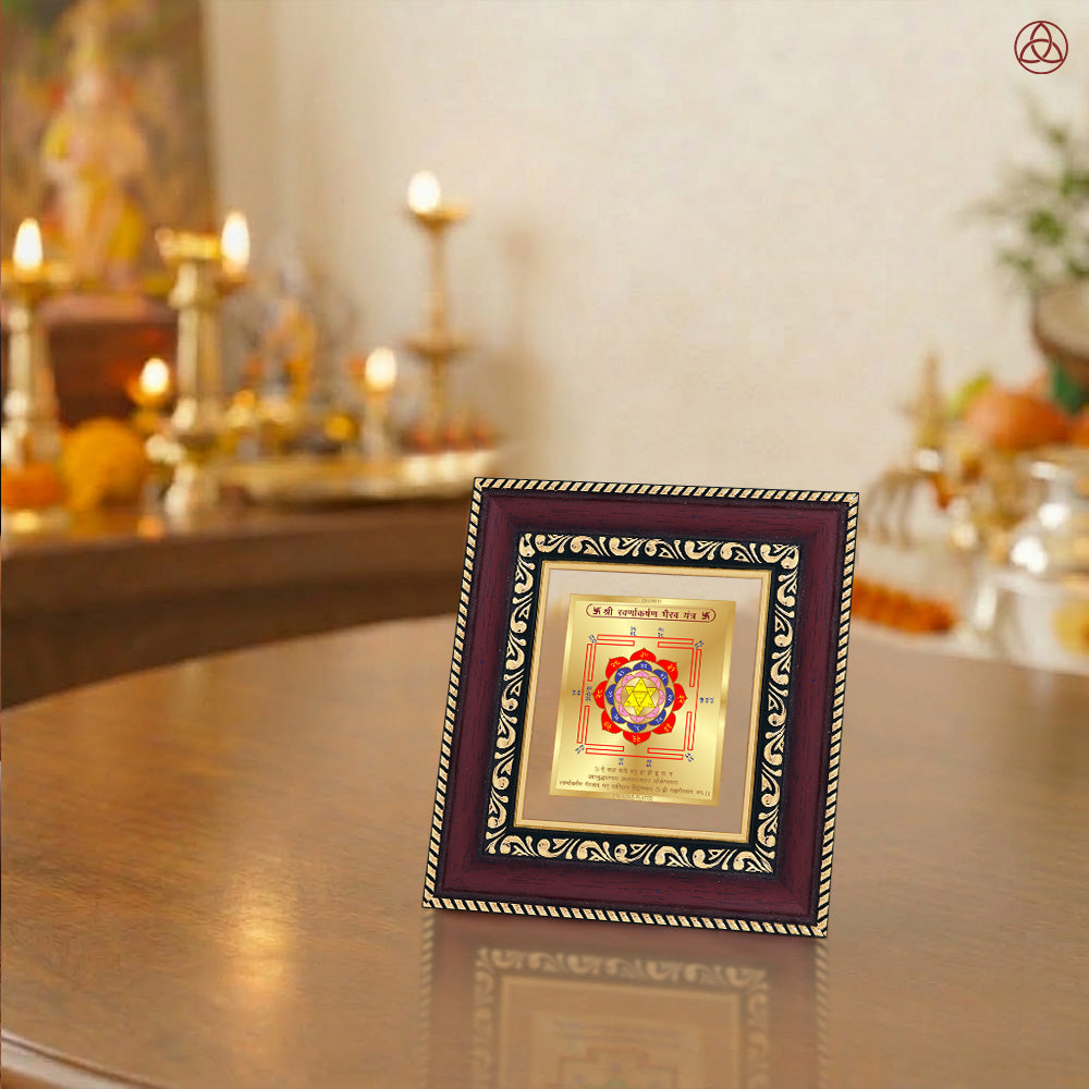 Swarn Akarshan Yantra displayed in a decorative frame on a wooden table, symbolizing planetary energies.