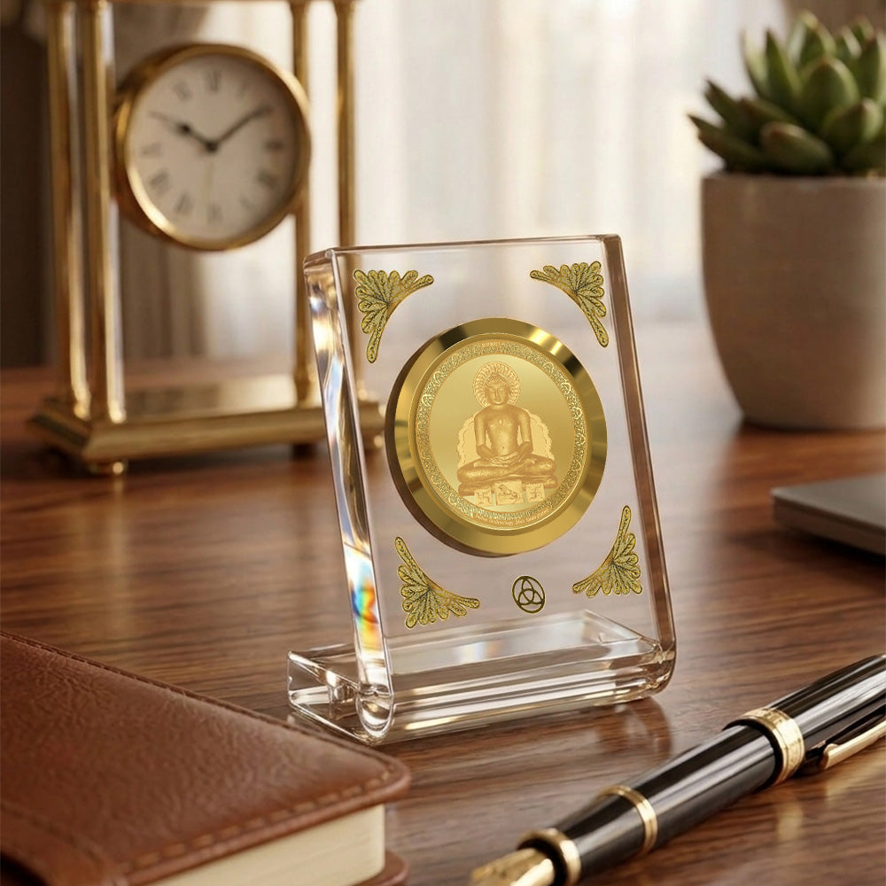 Lord Mahavir 24K gold plated car dashboard frame elegantly displayed on a wooden desk.