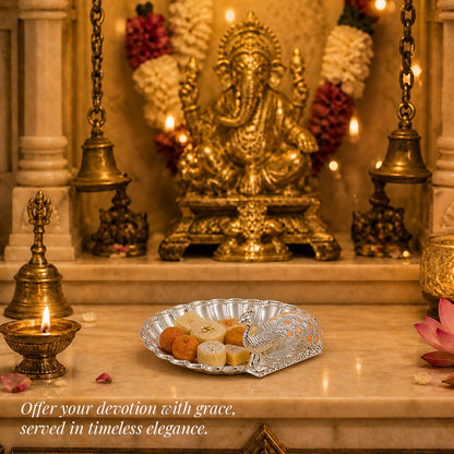 Diviniti Amber Peacock German Silver Dry Fruit Bowl elegantly adorned with sweets, set against a serene religious backdrop.