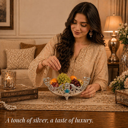 Person arranging fruit in a Diviniti German Silver Decorative Bowl with Turquoise Stone Accent, stylish home decor.
