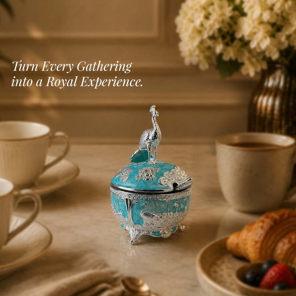 Diviniti German Silver Peacock Sugar Bowl with Spoon in turquoise blue finish on a dining table.