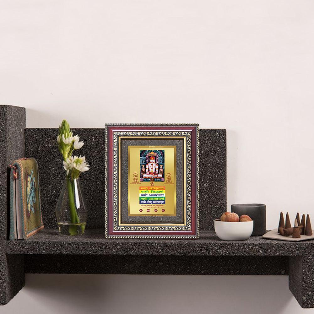Lord Adinath with Namokar Mantra framed photo on a decorative tabletop with flowers and decor.