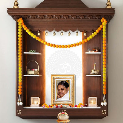 Mata Amritanandamayi photo frame in 24K Gold Plated Foil displayed on a beautifully decorated wooden shelf.