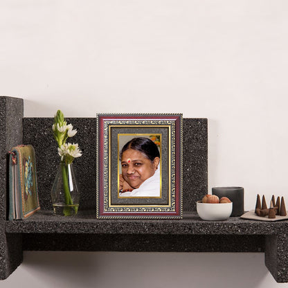 Mata Amritanandamayi photo frame displayed on a wall shelf, featuring a 24K gold-plated foil frame with elegant spiritual décor elements.