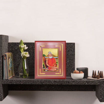 Baba Lokenath Wall Frame in 24k gold plated foil displayed on wooden shelf