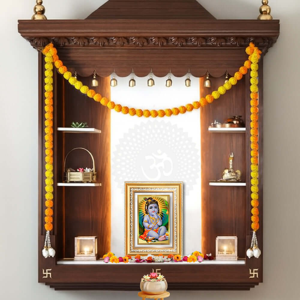 Devakinandana Wall and Tabletop Photo Frame surrounded by marigold garlands in a wooden shrine.