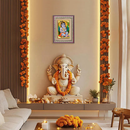 Bal Gopal | Baby Krishna wall frame displayed above a Ganesh idol in a beautifully decorated living space.