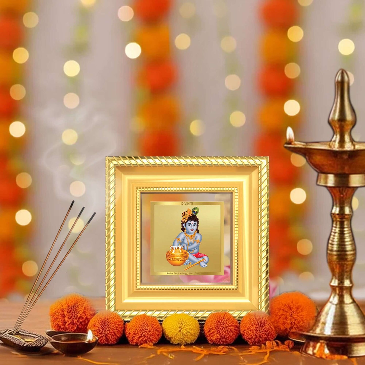 Makhan Gopal Baby Krishna Tabletop Frame displayed with brass diyas, incense holder, and marigold flowers in a peaceful home prayer corner