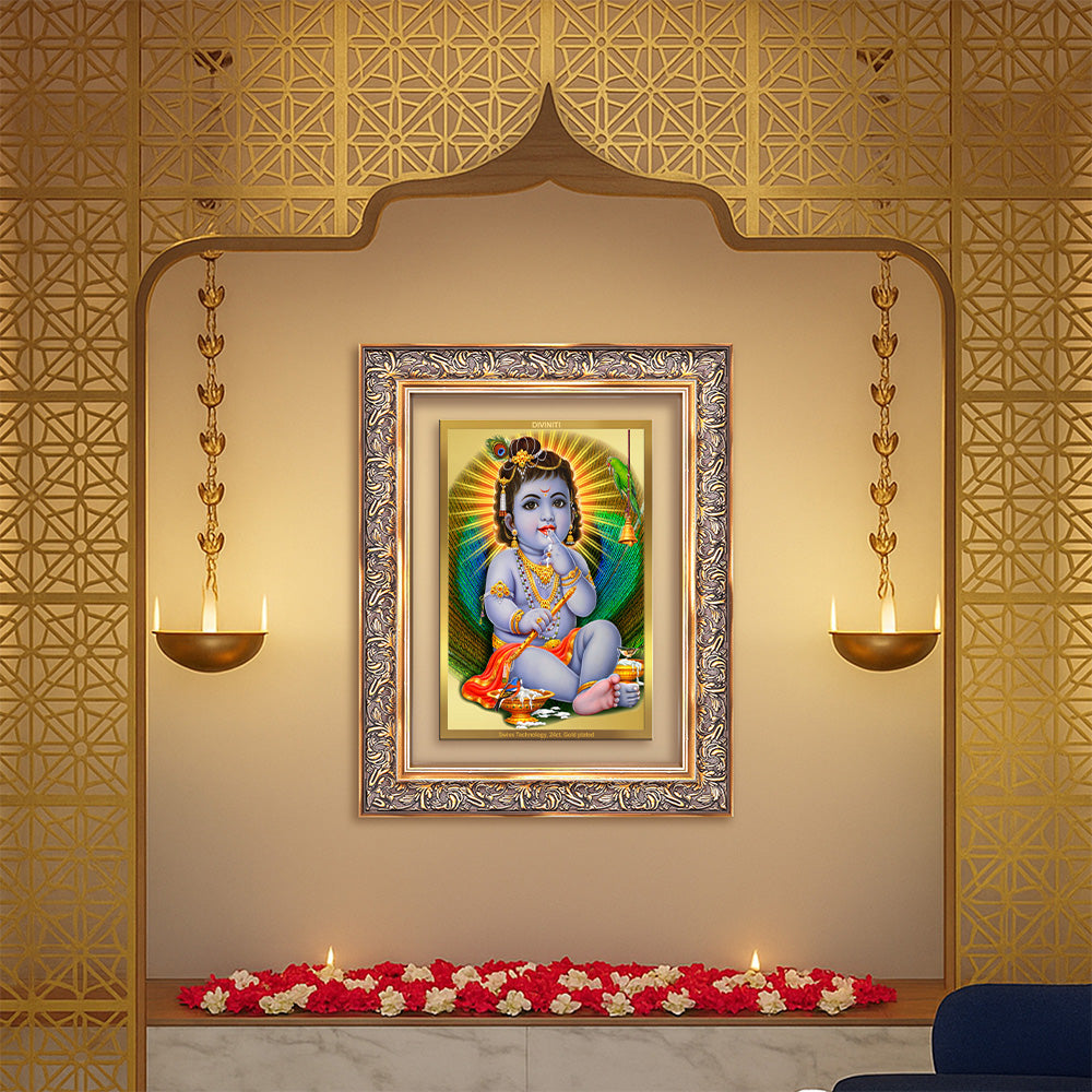 Baby Krishna gold photo frame displayed in a decorative wall setting with flowers and elegant lighting.