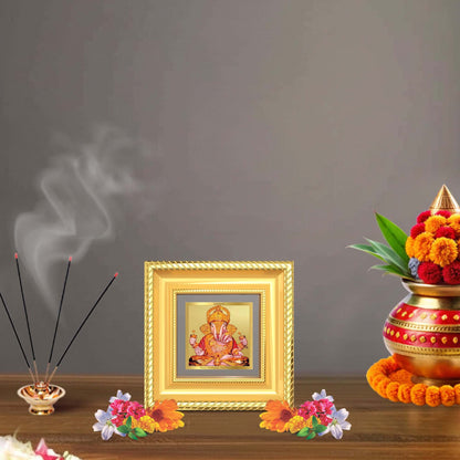 Dagdu Ganesh tabletop frame in 24K gold plated foil with flowers and incense holder on a decorative table.