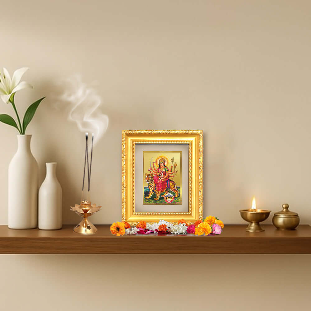 Durga Sherawali Mata framed artwork on a decorative shelf with flowers and incense, symbolizing strength and spiritual energy.