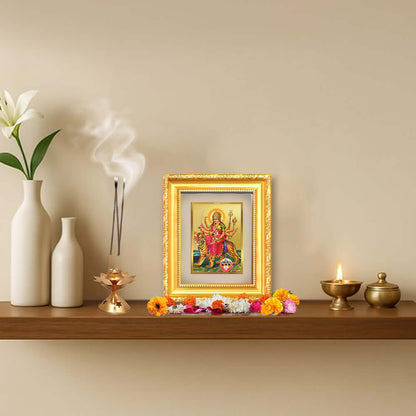 Durga Sherawali Mata framed artwork on a decorative shelf with flowers and incense, symbolizing strength and spiritual energy.