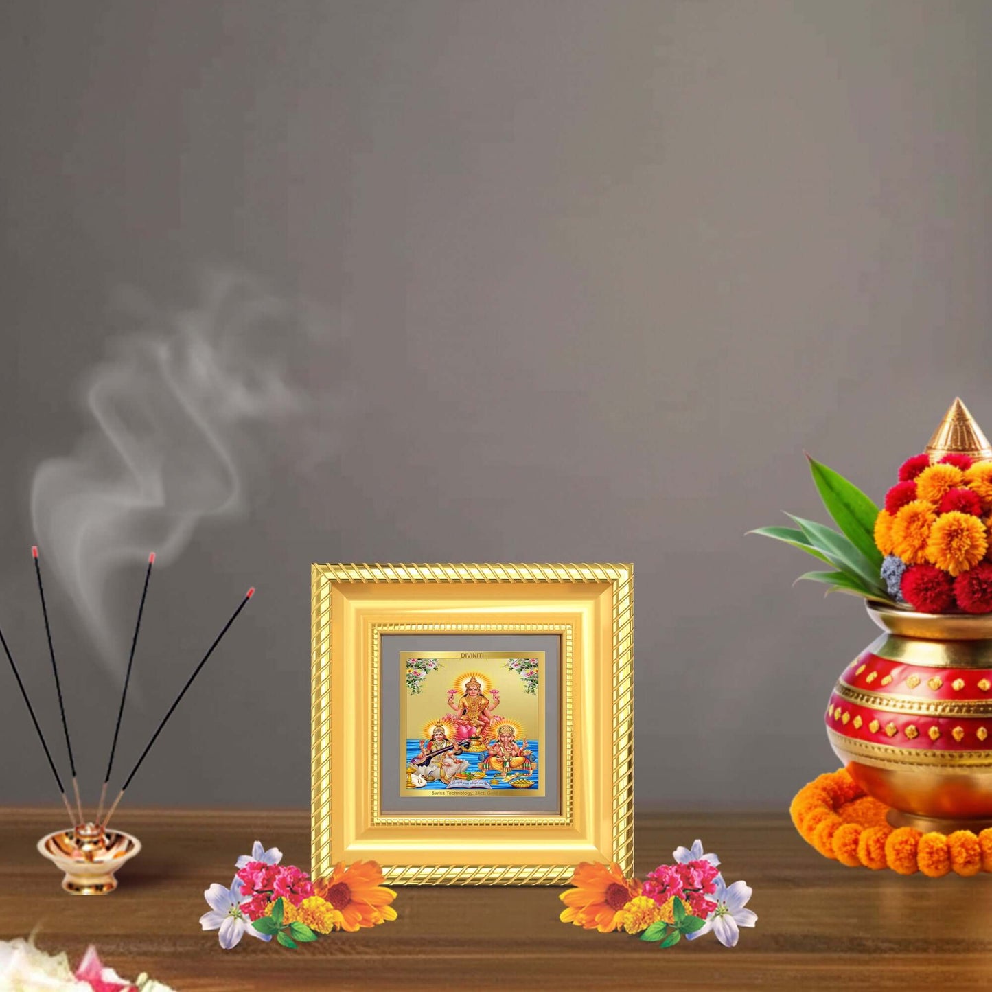 Goddess Lakshmi, Saraswati & Lord Ganesha framed artwork with flowers and incense on a festive tabletop.