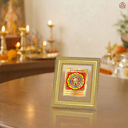 Maha Mrityunjay Yantra displayed in a decorative frame on a wooden table, symbolizing planetary energies.