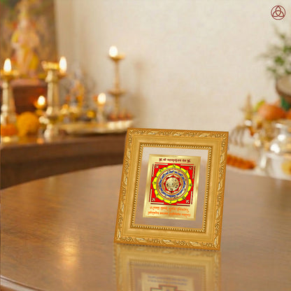 Maha Mrityunjay Yantra displayed in a decorative frame on a wooden table, symbolizing planetary energies.