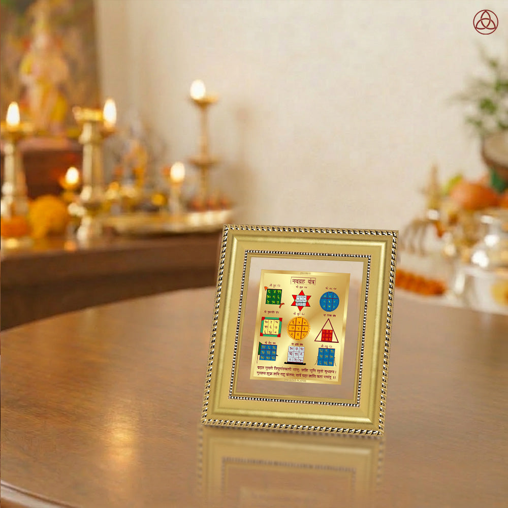  Navagraha Yantra displayed in a decorative frame on a wooden table, symbolizing planetary energies.
