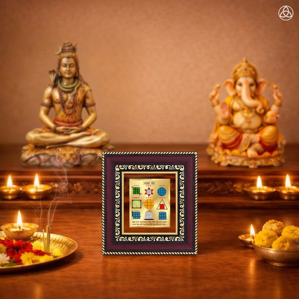 Navagraha Yantra displayed on a decorated altar with candles and idols of Hindu deities for spiritual harmony.