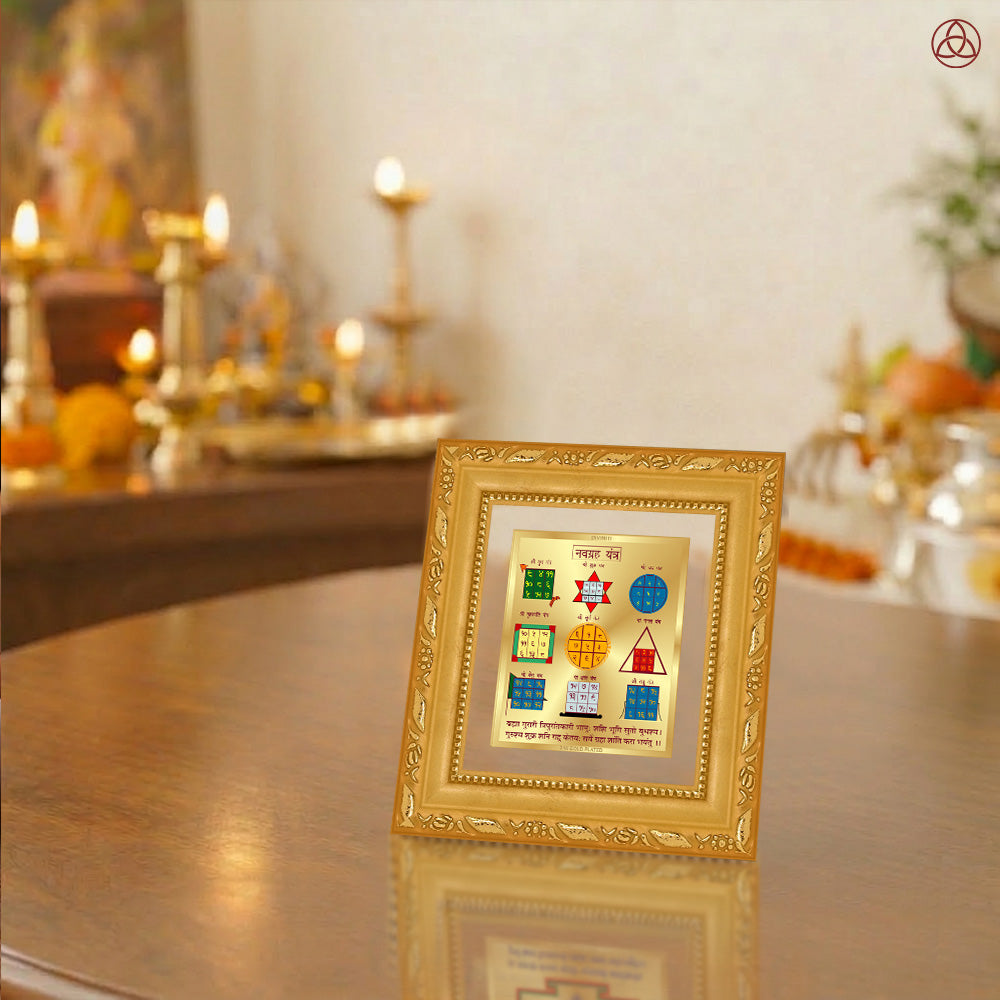Navagraha Yantra displayed in a decorative frame on a wooden table, symbolizing planetary energies.
