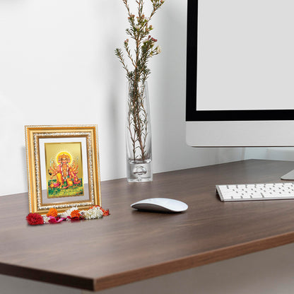 Panchmukhi Hanuman wall and tabletop photo frame in 24K gold-plated foil on a wooden desk with decorative elements.