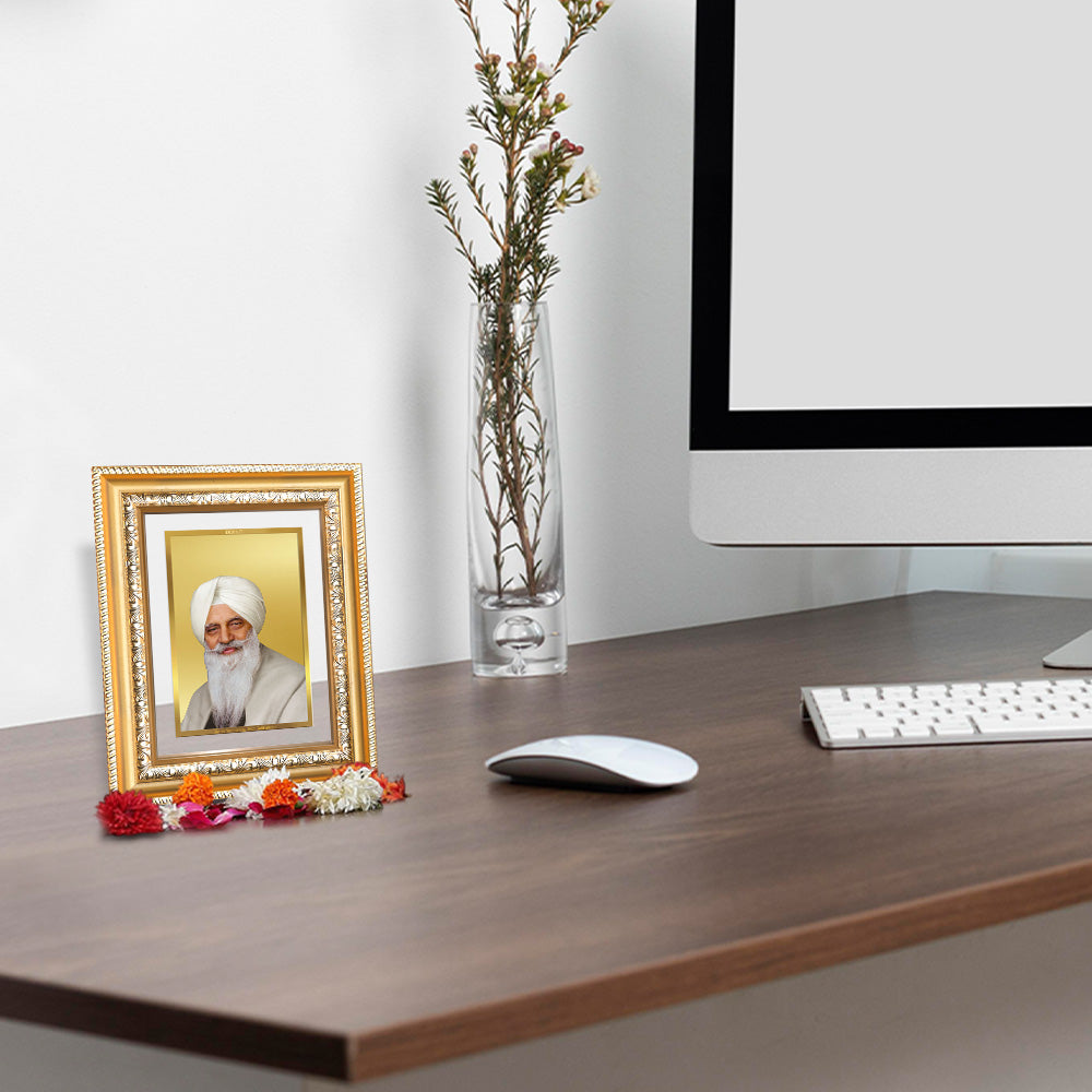 Baba Gurinder Singh Ji wall and tabletop photo frame in gold on a wooden desk