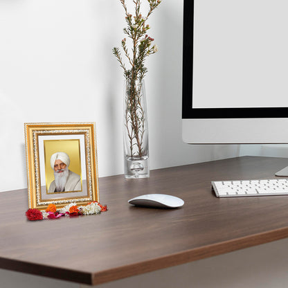 Baba Gurinder Singh Ji wall and tabletop photo frame in gold on a wooden desk