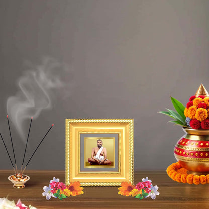 Sri Ramakrishna Paramahamsa Tabletop Frame in 24K Gold Plated Foil displayed in a beautifully decorated wooden wall shrine.