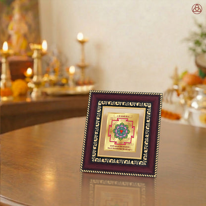 Saraswati Yantra displayed in a decorative frame on a wooden table, symbolizing planetary energies.