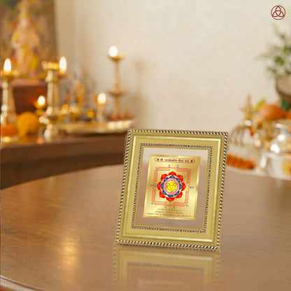 Swarn Akarshan Yantra displayed in a decorative frame on a wooden table, symbolizing planetary energies.