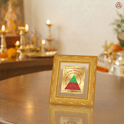 Vahan Durghtna Yantra displayed in a decorative frame on a wooden table, symbolizing planetary energies.