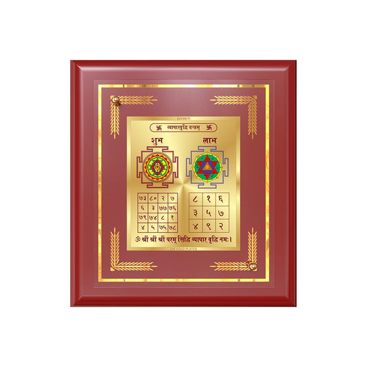 Vyapar Vriddhi Yantra displayed in a golden frame on a wooden table, surrounded by traditional decor.